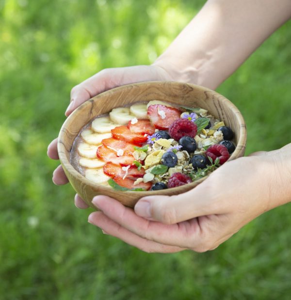 přírodní miska z teakového dřeva na smoothie bowl v dlaních