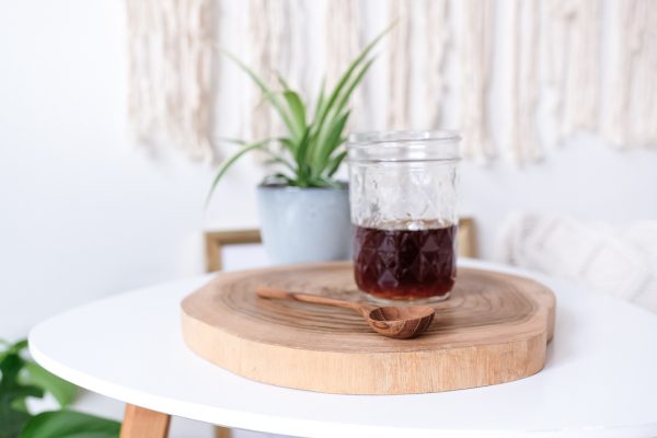 přírodní špalek z teakového dřeva s kávou a lžičkou detail